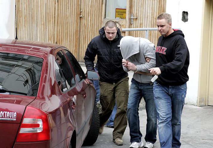 Lögreglumenn sjást hér koma með einn þeirra, sem voru handteknir eftir að smyglið kom upp, í héraðsdóm. Þar var hann úrskurðaður í gæsluvarðhald.