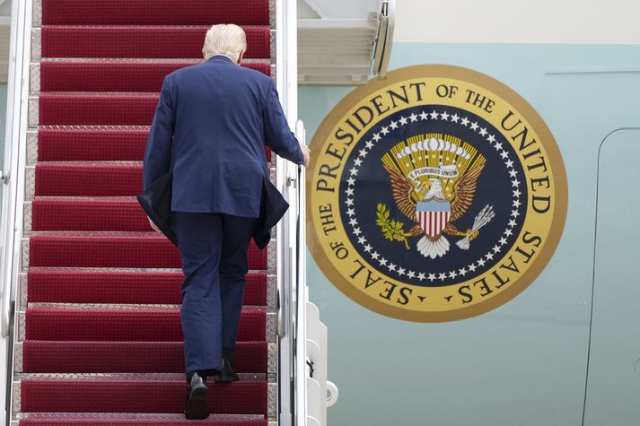 Donald Trump á leið upp í flugvél forsetaembættisins í gær.