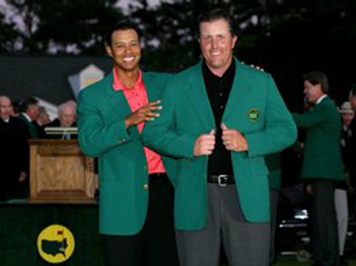 Tiger Woods afhendir hér Mickelson í græna jakkann smekklega sem sigurvegarinn á Masters klæðist jafnan í lokin. Woods sigraði á mótinu í fyrra, en hafnaði í þriðja sæti í ár
