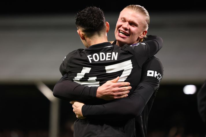 Erling Haaland fagnar með Phil Foden í sigri Manchester City á Craven Cottage í kvöld.