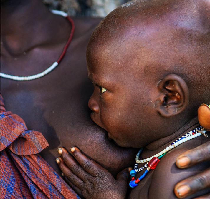 Kona af þjóðflokknum Ovahimba gefur barni sínu brjóst en rétt er að geta þess að þann þjóðflokk er ekki að finna í Úganda heldur einungis Namibíu og Angóla.