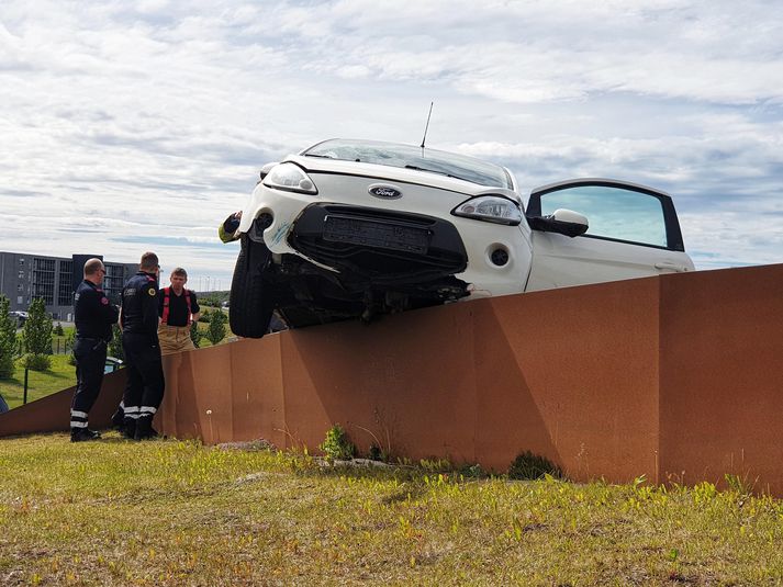 Bíllinn endaði uppi á grindverki