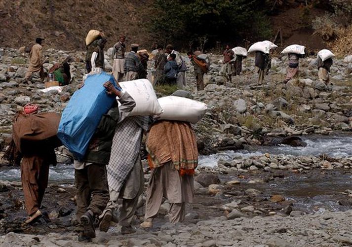 Fólk sem lifði skjálftann af heldur hér heim á leið eftir að hafa fengið matvæli hjá hjálparstarfsmönnum.
