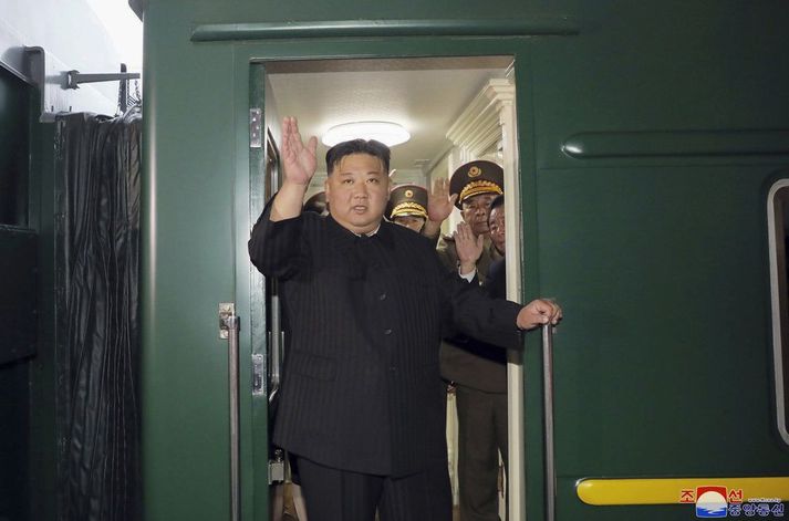 Kim Jong-un veifar þegar hann stígur upp í lestina í Pyongyang. 