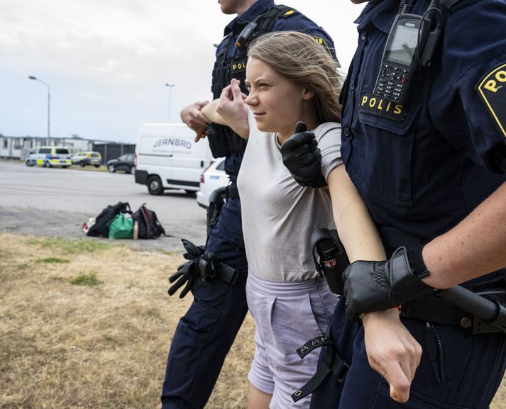 Greta Thunberg borin burt af lögreglumönnum við mótmæli við höfnina í Malmö 19. júní.