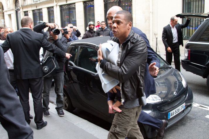Hér er Jay-Z með Blue Ivy í fanginu, en hlífir henni fyrir ágengum ljósmyndurum.
