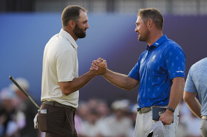 Bryson DeChambeau tekur í höndina á Scottie Scheffler í lok annars keppnisdags á Opna breska meistaramótinu í golfi.