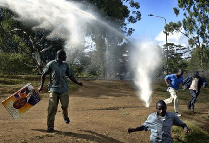Stuðningsmenn forsetaframbjóðandans Raila Odinga hlaupa undan vatnsbyssum óeirðalögreglu í fátækrahverfinu Kibera í Naíróbí.
