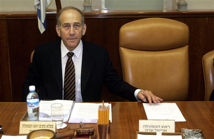 Ehud Olmert, starfandi forsætisráðherra Ísraels, situr við hliðina á auðum stól Ariels Sharons, forsætisráðherra, á ríkisstjórnarfundi í morgun.
