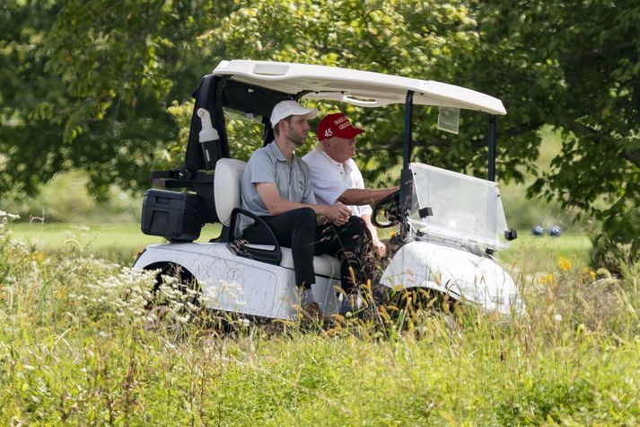 Donald Trump og sonur hans Eric á golfvelli í Virginíu í gær.