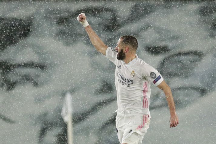 Karim Benzema fagnar marki sínu í rigningunni í Madrid.