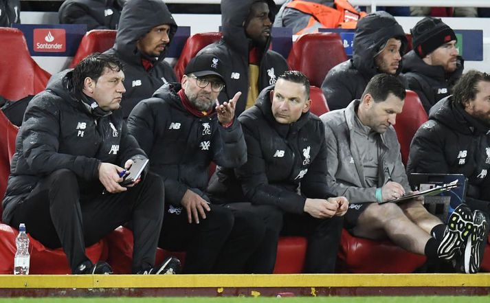 Jurgen Klopp ræðir við sína aðstoðarmenn en talið er að starfsmaðurinn sem um ræðir sé aftar í keðjunni.