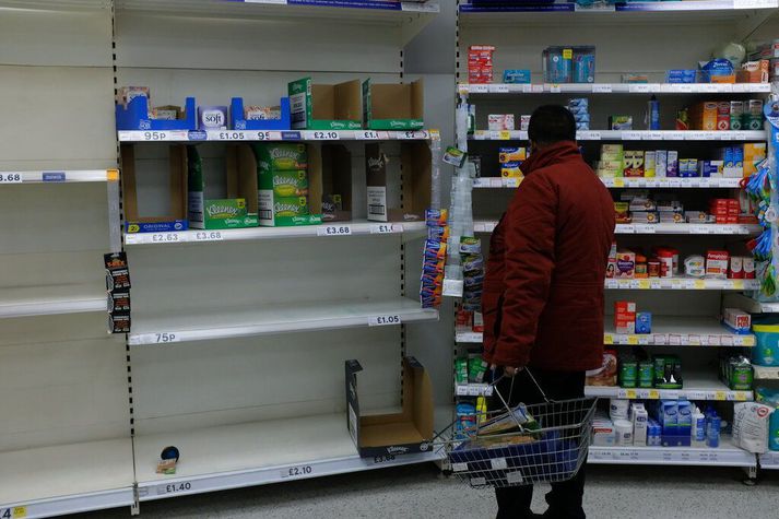 Tómar hillur í verslun Tesco í London á föstudag. Verslunareigendur líkja kaupæðinu vegna kórónuveirufaraldursins við jólaörtröðina. Svo rammt kveður að því að fólk hamstri nauðsynjar að stærstu verslunarkeðjur landsins hvetja fólk til að róa sig.