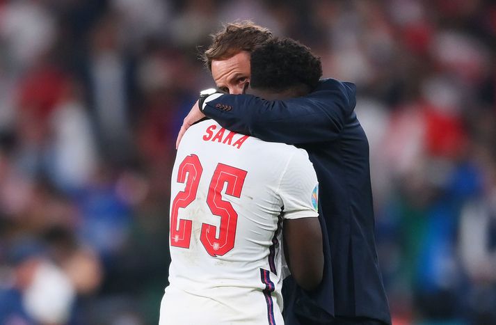 Gareth Southgate hughreystir Bukayo Saka eftir að hann klúðraði síðustu spyrnu Englands í vítaspyrnukeppninni gegn Ítalíu í úrslitaleik EM.