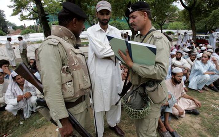 Pakistanskir hermenn taka niður upplýsingar hjá stúdentum sem gefist hafa upp