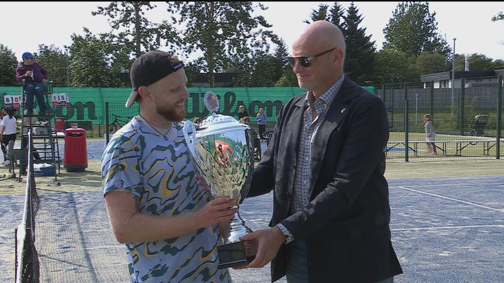 Egill hampar bikarinn með bros á vör.