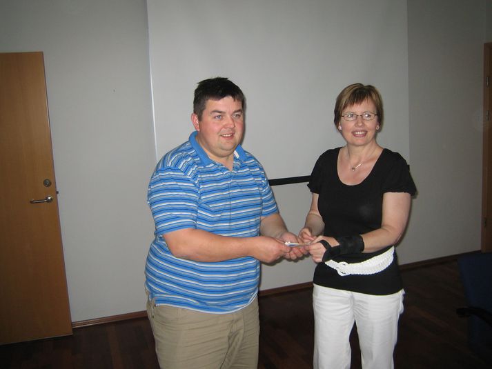 Neil Dymock afhendir Petrínu peningagjöfina.