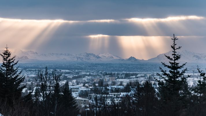 Sólstafir yfir Reykjanesfjallgarði í dag, séðir frá Bústaðavegi í Reykjavík.