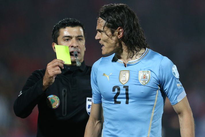 Edinson Cavani fær hér fyrra gula spjald leiksins.