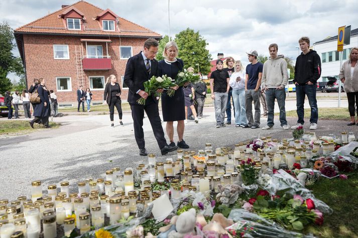 Ulf Kristersson, forsætisráðherra Svíþjóðar, til vinstri, og Magdalena Andersson, leiðtogi Jafnaðarmannaflokksins, heimsækja minningarreit fyrir utan skóla í Fagersta í Svíþjóð,