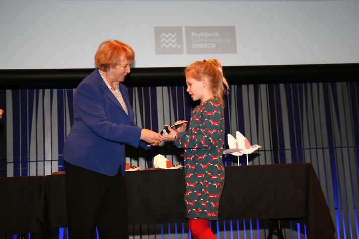 Frú Vigdís afhendir Margréti Maríu Hallgrímsdóttur nemanda í Austurbæjarskóla íslenskuverðlaunin en hátt í eitt hundruð börn og ungmenni fengu í dag íslenskuverðlaun unga fólksins í bókmenntaborginni Reykjavík.