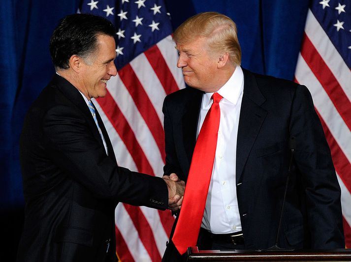Romney og Trump takast í hendur.