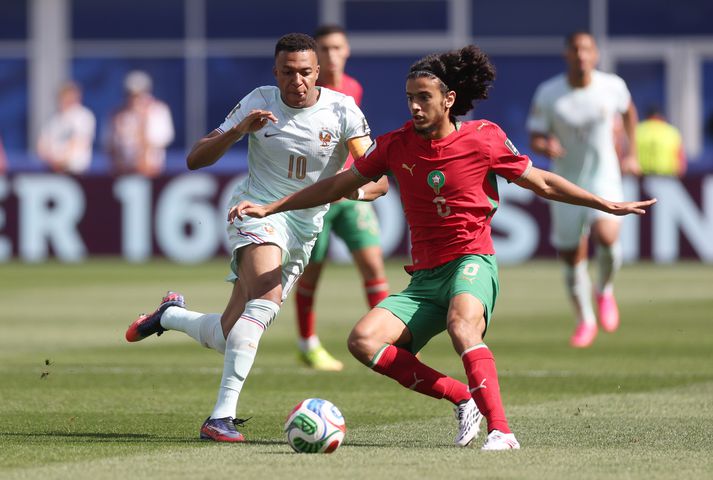 Hinn ungi Ayyoub Bouaddi skýlir boltanum fyrir Kylian Mbappe í leik Marokkó og Frakklands í átta liða úrslitum HM.