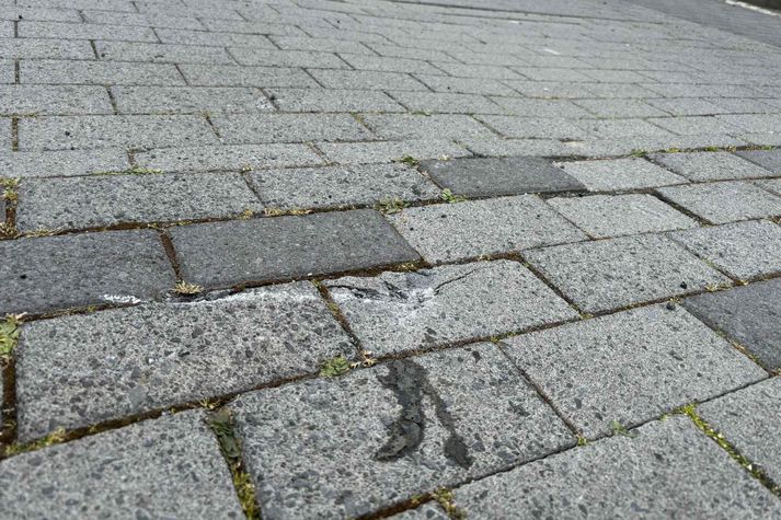 Hjólið skildi eftir sig sprungu í gangstéttarhellum þegar það féll til jarðar. 