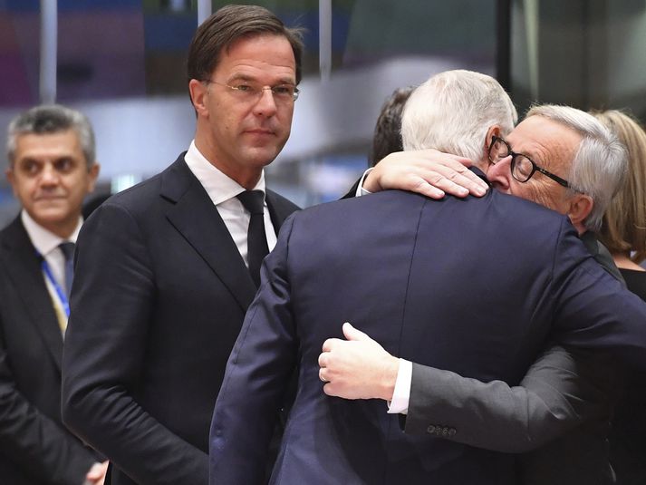 Michel Barnier, formaður samninganefndar ESB, og kollegi hans, Jean-Claude Juncker, forseti framkvæmdastjórnar ESB, fallast í faðma. Nordicphotos/AFP