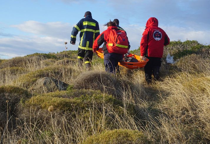 Björgunarmenn flytja lík barns sem drukknaði við Lesbos af ströndinni.