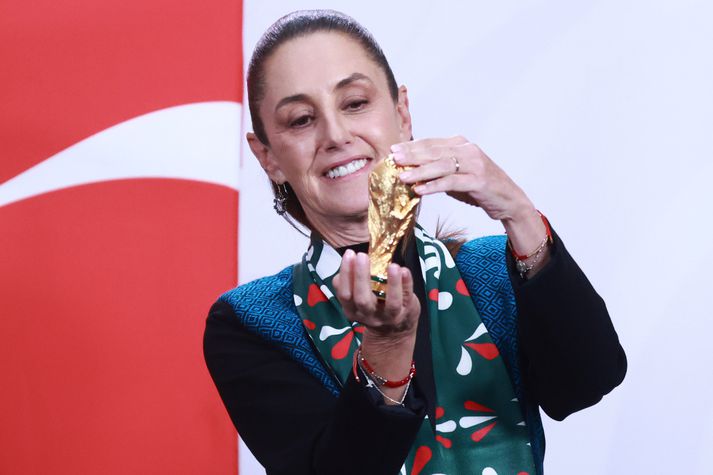 Claudia Sheinbaum, forseti Mexíkó, með litla útgáfu af heimsbikarnum. Hún vill leysa mögulega umferðateppu með því að fólk haldi sig heima.