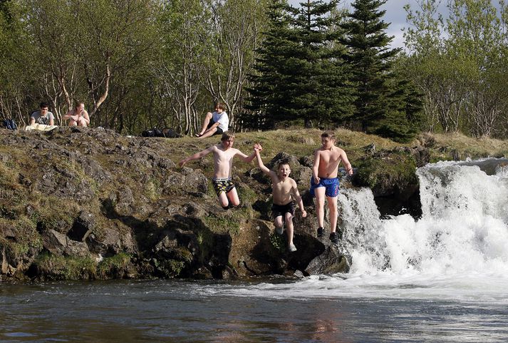 Hér sést hvernig ungir piltar leika sér í Elliðaárdalnum á góðum sumardegi.