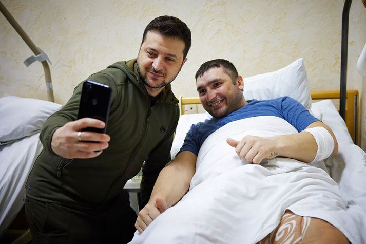 Volodymyr Zelenskyy forseti tekur sjálfu með særðum hermanni á sjúkrahúsi í Kænugarði.