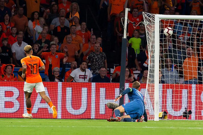 Memphis Depay skorar framhjá Manuel Neuer í leiknum í kvöld.