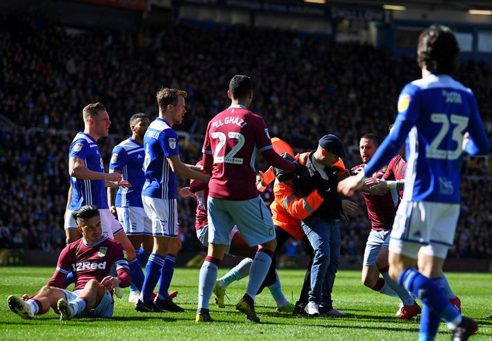 Paul Mitchell er hér dreginn í burtu en Jack Grealish situr á grasinu.