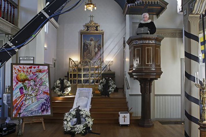 Tóm kista, prestur og afar litríkt málverk.