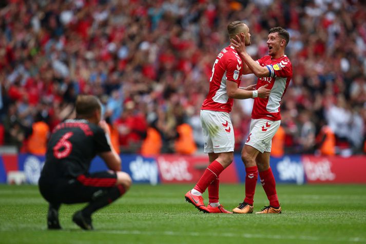 Lee Cattermole fylgist svekktur með úr fjarlægð á meðan Patrick Bauer og Jason Pearce, leikmenn Charlton, fagna sæti í b-deildinni.