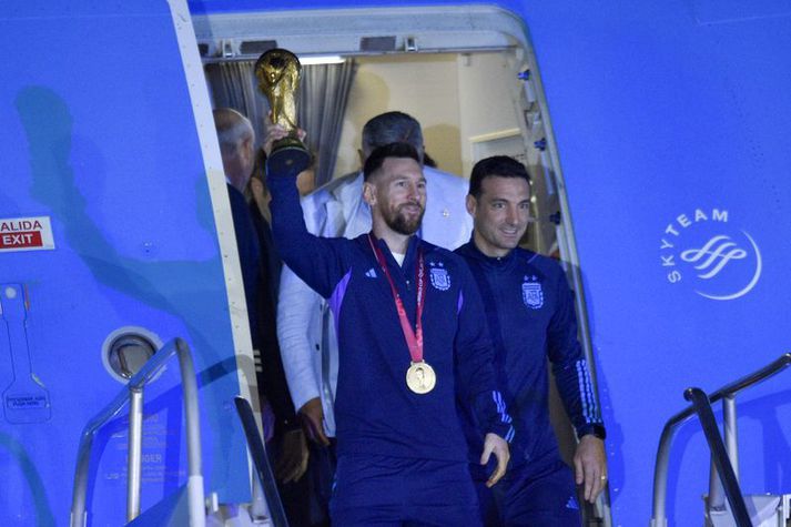 Lionel Messi og Lionel Scaloni stíga út úr flugvélinni í Buenos Aires. Messi heldur að sjálfsögðu á bikarnum.
