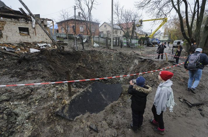 Íbúar Lviv virða fyrir sér gíg eftir að stýriflaug lenti þar í gær.