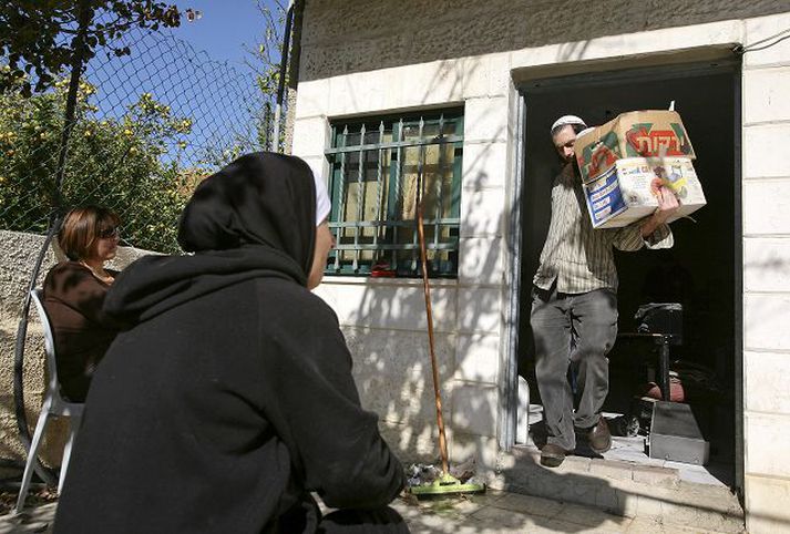 Hús tekið Palestínsk kona horfir á ísraelskan landtökumann bera eigur palestínskrar fjölskyldu út úr húsi í Austur-Jerúsalem í byrjun mánaðarins þegar ísraelsk fjölskylda tók yfir hús í hverfi araba. Fréttablaðið/AP