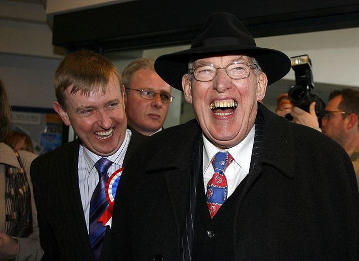 Ian Paisley brosir breitt. Harðlínumenn bæði mótmælenda og kaþólskra sigruðu í þingkosningunum á Norður-Írlandi á föstudag. Nú verða þeir að mynda stjórn.