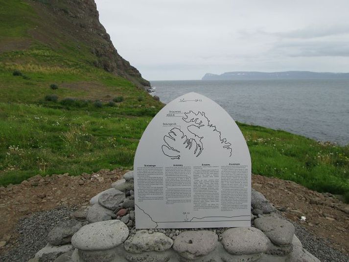 Minnisskjöldurinn í Stigahlíð á Bolungarvík. Skjaldaroddurinn vísar á þann stað þar sem harm- leikurinn varð árið 1942. Lengi á eftir var börnum bannað að fara til fjöru en þar fundust lík unnvörpum.