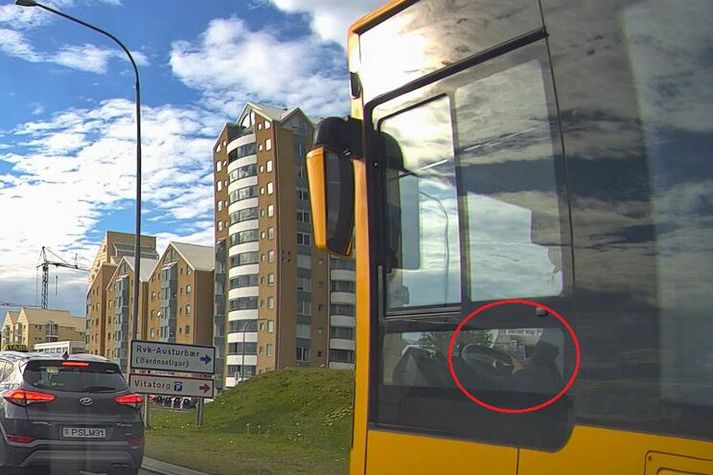Bílstjórinn með fingur og augu á síma en fótinn á bensíngjöfinni.