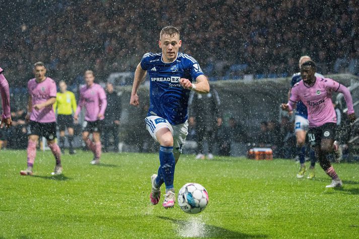 Sævar Atli Magnússon, leikmaður Lyngby á harða spretti á eftir boltanum á blautum vellinum.