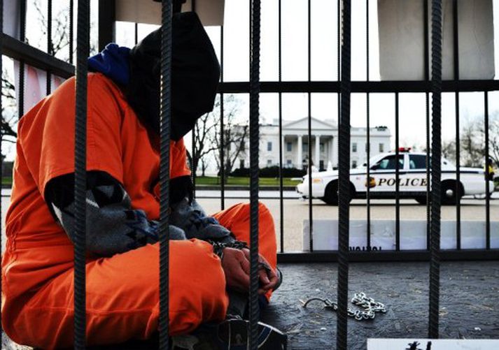 Fangabúðunum hefur verið mótmælt víða um heim. Á þessari mynd sést mótmælandi hlekkja sjálfan sig í búri fyrir utan Hvíta húsið í Washington, höfuðborg Bandaríkjanna.