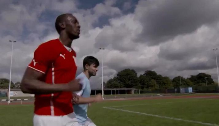 Bolt hleypur með Aguero.