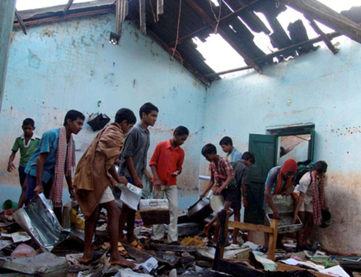 Börn bjarga eigum sínum úr farfuglaheimili sem eyðilagt var af hindúum.