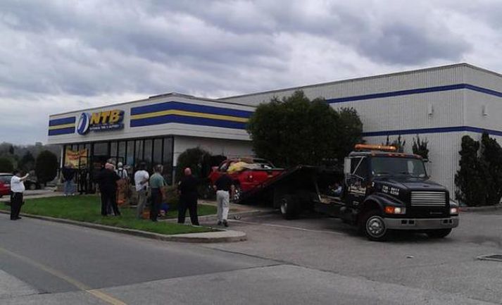 Trukkurinn sést hér dreginn út úr byggingunni sem hann klessti á.