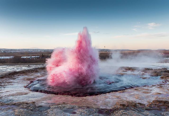 Hverinn Strokkur gaus rauðu í nokkur skipti eftir að litarefninu var hellt út í. Landeigendur tilkynntu málið til lögreglu í gær.