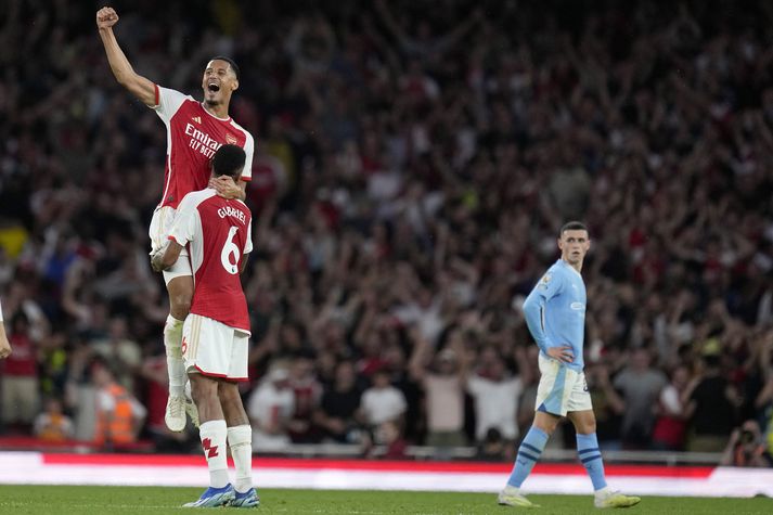 Phil Foden fylgist með Arsenal mönnunum William Saliba og Gabriel fagna sigri á Manchester City.